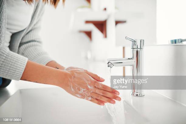 Cropped shot of a woman washing her hands in the bathroom at home