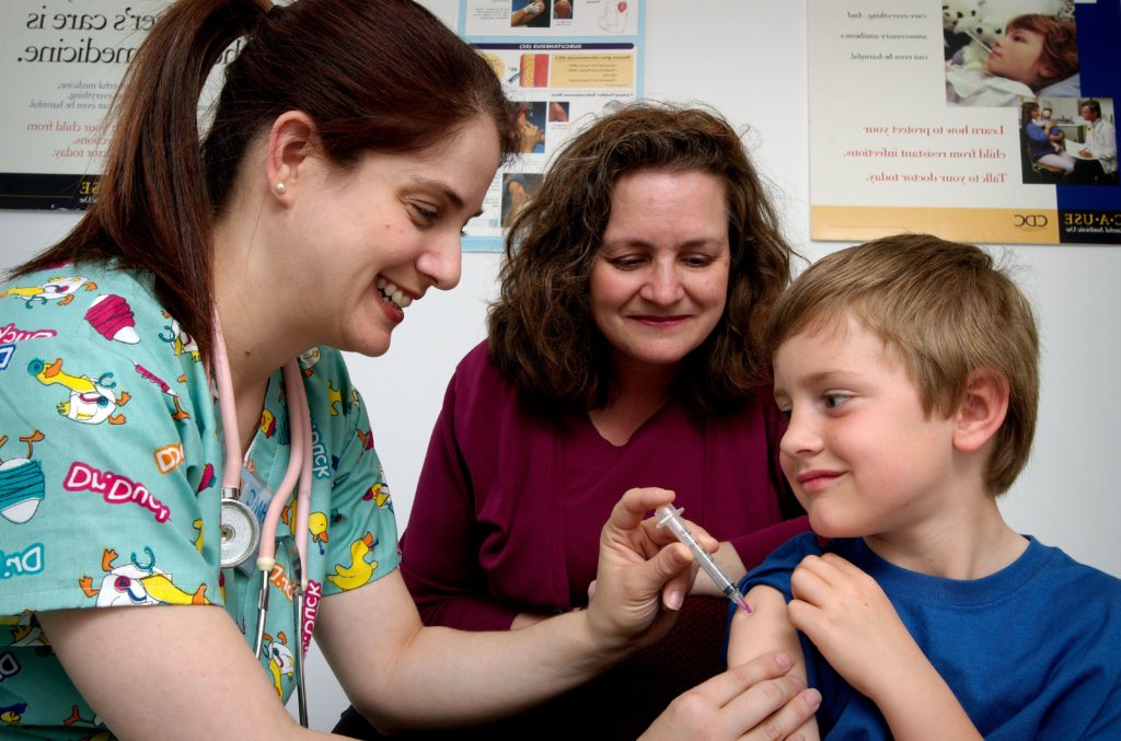 Nurse administering an intramuscular vaccination in the left sho